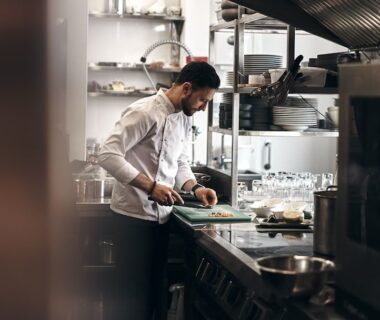 Chef préparant un plat sur une planche dans une cuisine professionnelle