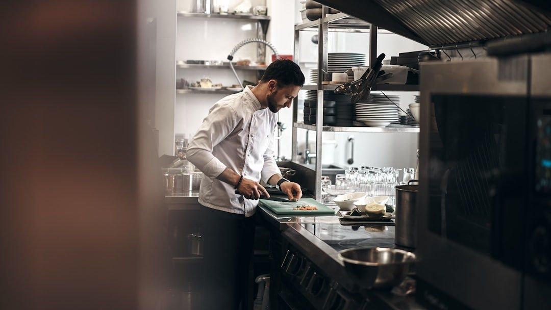Chef préparant un plat sur une planche dans une cuisine professionnelle