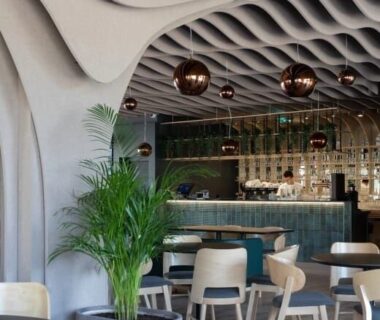 Restaurant moderne avec plafond ondulé et suspensions cuivrées