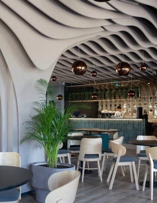 Restaurant moderne avec plafond ondulé et suspensions cuivrées